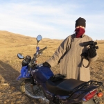 Kate bundled up in a traditional wool Mongolian coat, binoculars in hand, ready to count wildlife.
