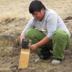Park biologist, Uuganaa, placing a camera trap near a water source to capture photographs of animals coming to drink.