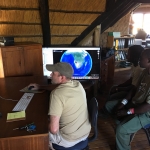 Minnesota Zoo's Jeff Muntifering with Save the Rhino Trust staff working on the new computer and monitor set-up supported by the Minnesota Zoo.